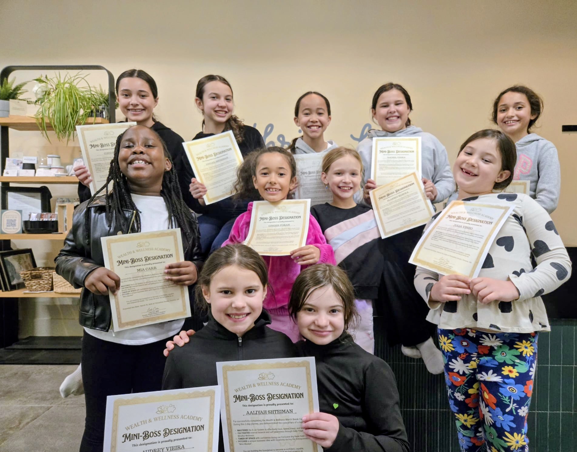 Pitch day and graduation — girls holding Mini-Boss certificates